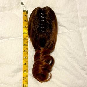 Hair clip. Pony tail. Light brown hair with reddish highlights.